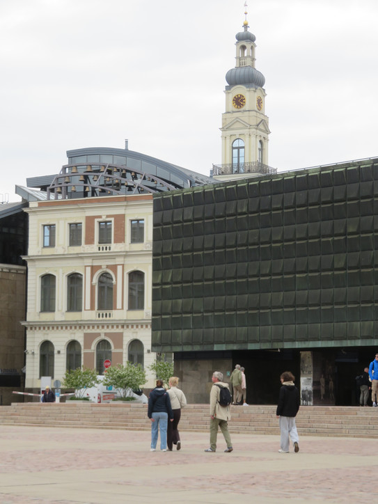 Foto des Okkupationsmuseums in Riga (Lettland) mit seitlichem Blick auf das Rathaus mit halbem Runddach und Rathausturm im Hintergrund