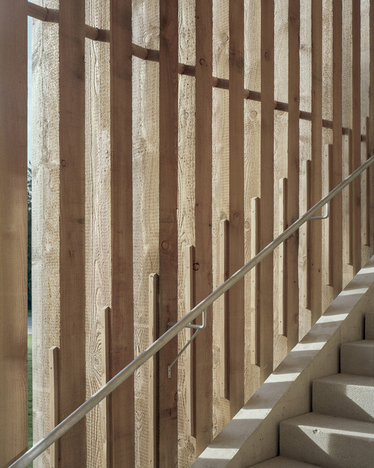 Foto eines Treppenausschnitts mit Geländerlauf und Holzbalken im Hintergrund